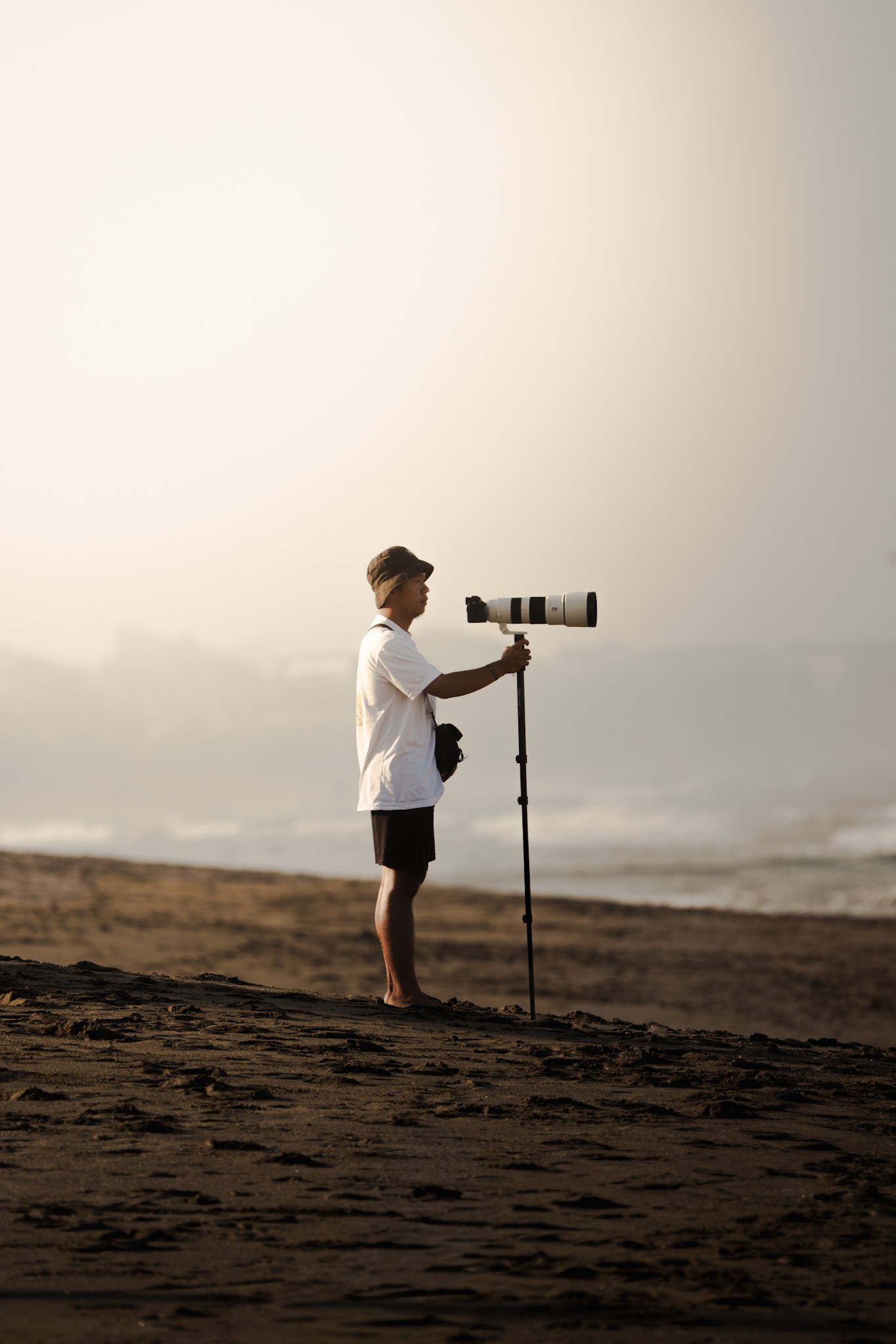 Abid on the sand at Batu Bolong with his long lens on a monopod