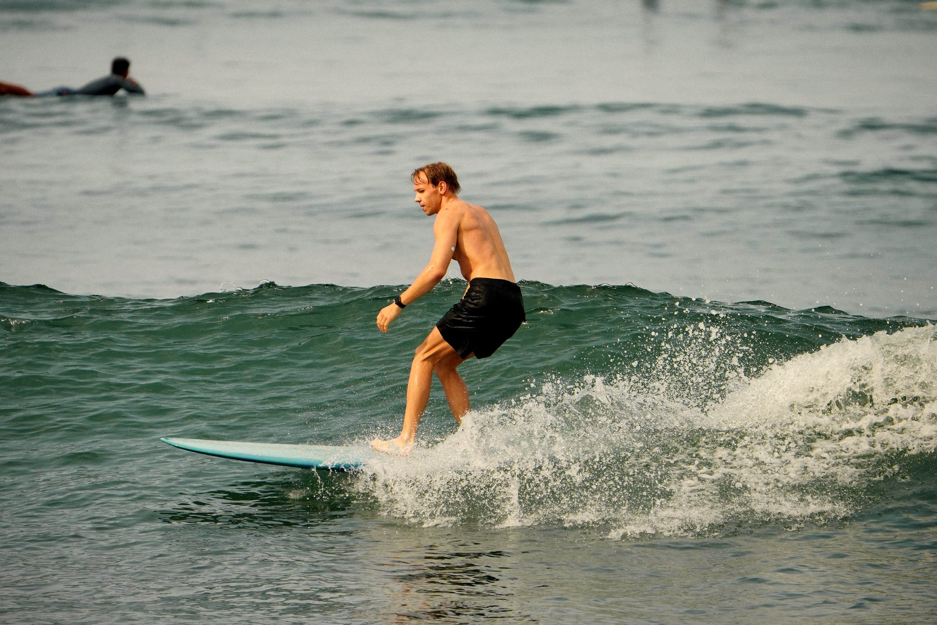 Surfer leaning into a turn through the whitewater, close up
